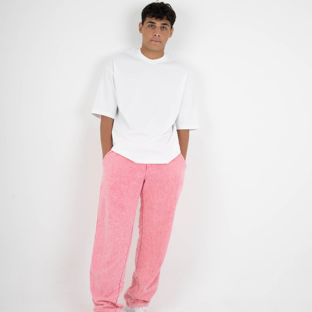 Person wearing a white t-shirt and pink pants on a white background