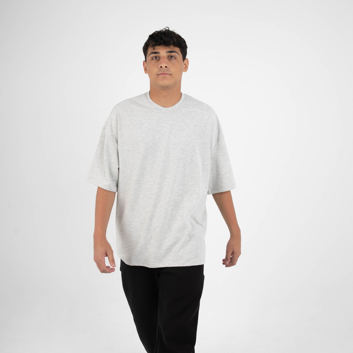 Person wearing a white t-shirt and black pants on a white background