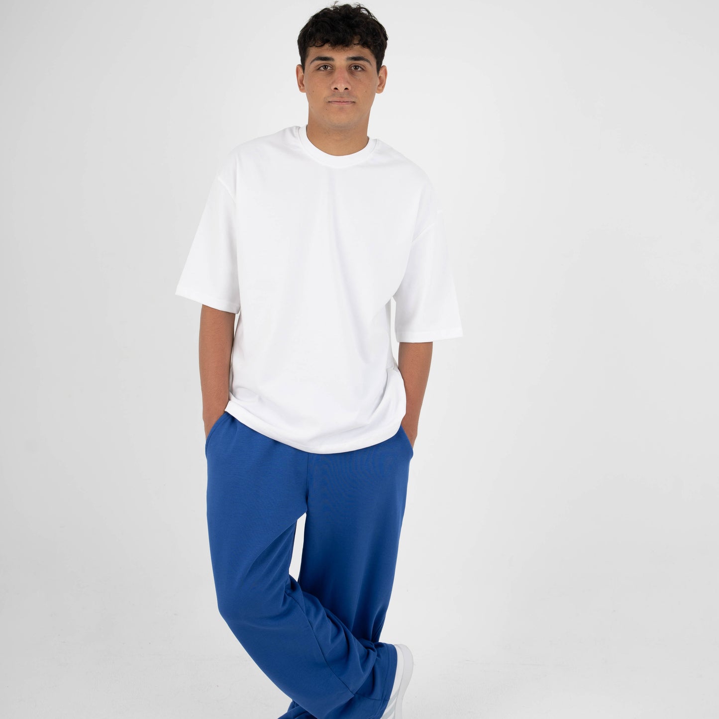 Person wearing a white t-shirt and blue pants on a white background