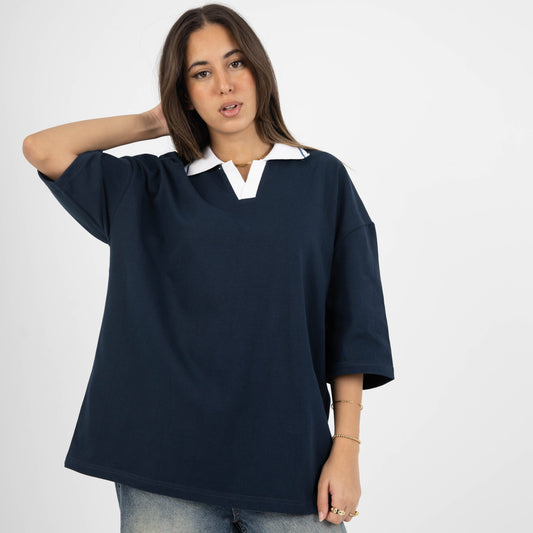 Woman wearing a navy blue oversized shirt with a white collar on a white background