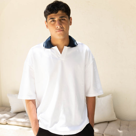 Man wearing a white shirt with a blue collar in an outdoor setting