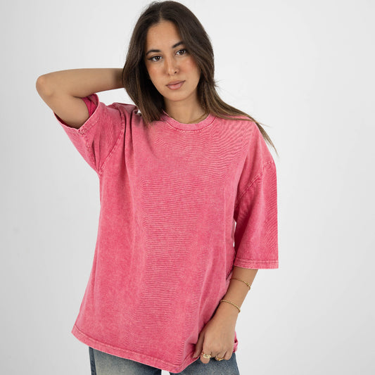 Woman wearing a pink t-shirt and jeans on a white background